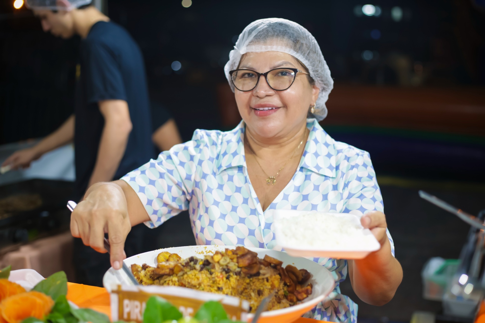 Prato típico servido por cozinheira